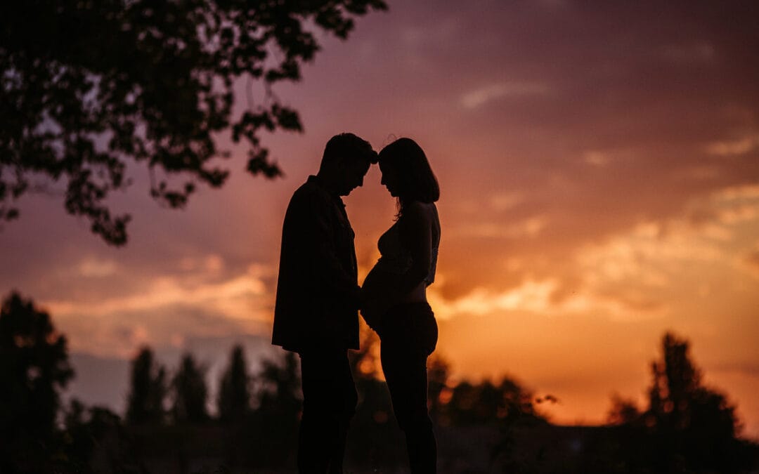 Reportaje de embarazo al atardecer en el campo en otoño